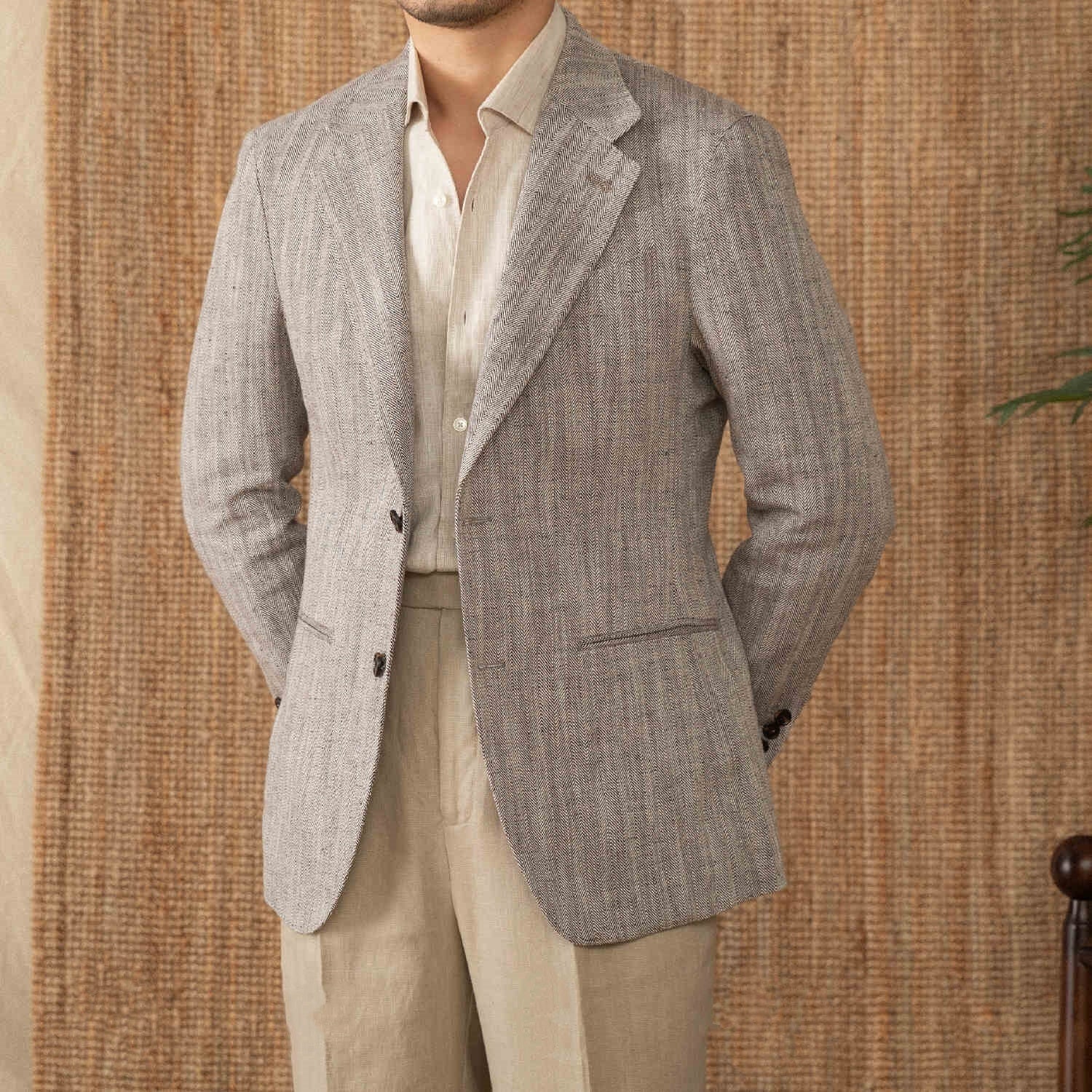 Linen herringbone business suit jacket in gray, featuring a flat collar and double-breasted placket, styled for gentlemen.